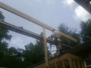 Carpenter setting a ridge beam over a new addition frame — Ice Dam Removal by Roofing Brothers in Scranton
