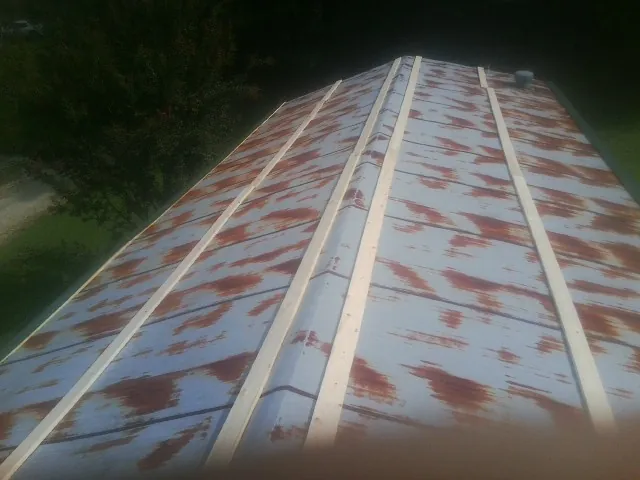 Rusted metal roof panels with new wood purlins before replacement — Storm Damage Roof Repair in Scranton by Roofing Brothers