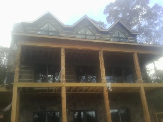 Dormers and porch framing on a large log home under construction — Roof Coating work by our crew in Scranton